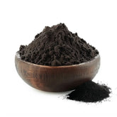 Bowl of fine black activated charcoal powder made from coconut shells, on a white background - Canada Vitalife