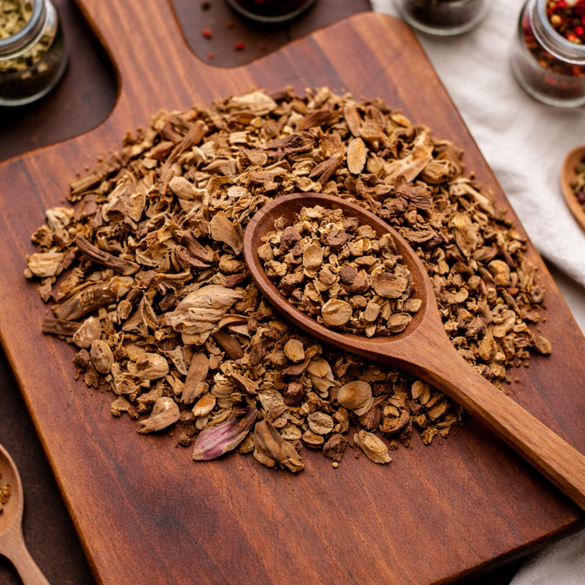 Dried cut and sifted angelica root displayed on a wooden board for herbal tea and culinary use.