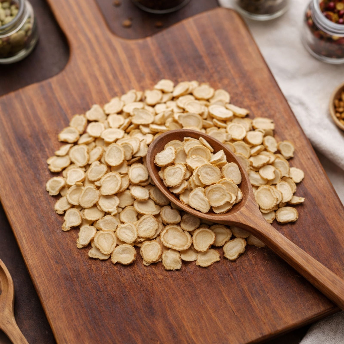 Thinly sliced creamy-tan Ontario ginseng roots on a wooden surface.