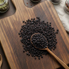 Whole dried dark purple elderberries (Sambucus nigra) on a rustic wooden background – CanadaVitaLife