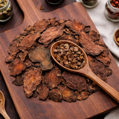 Dried Fo-ti root slices displayed on a rustic wooden board for traditional herbal tea.